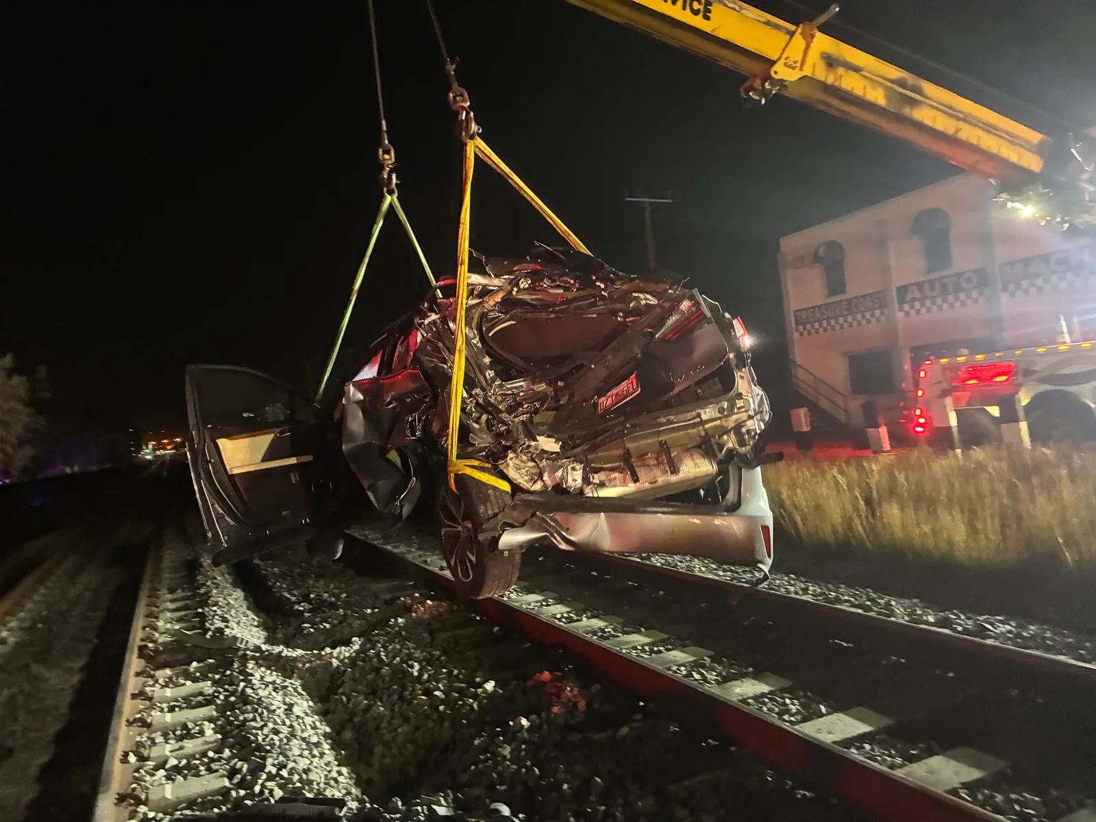 KW Wrecker Service nighttime recovery of a severely damaged sedan from railroad tracks