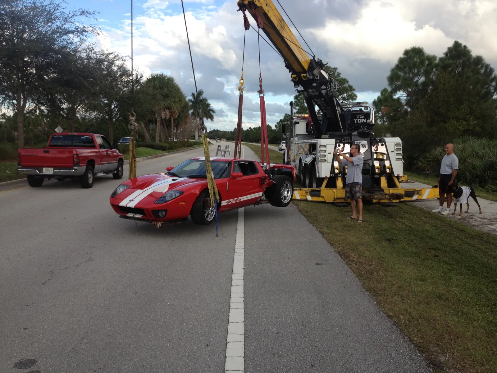 KW Wrecker Service 75-ton rotator carefully lifting a red Ford GT supercar