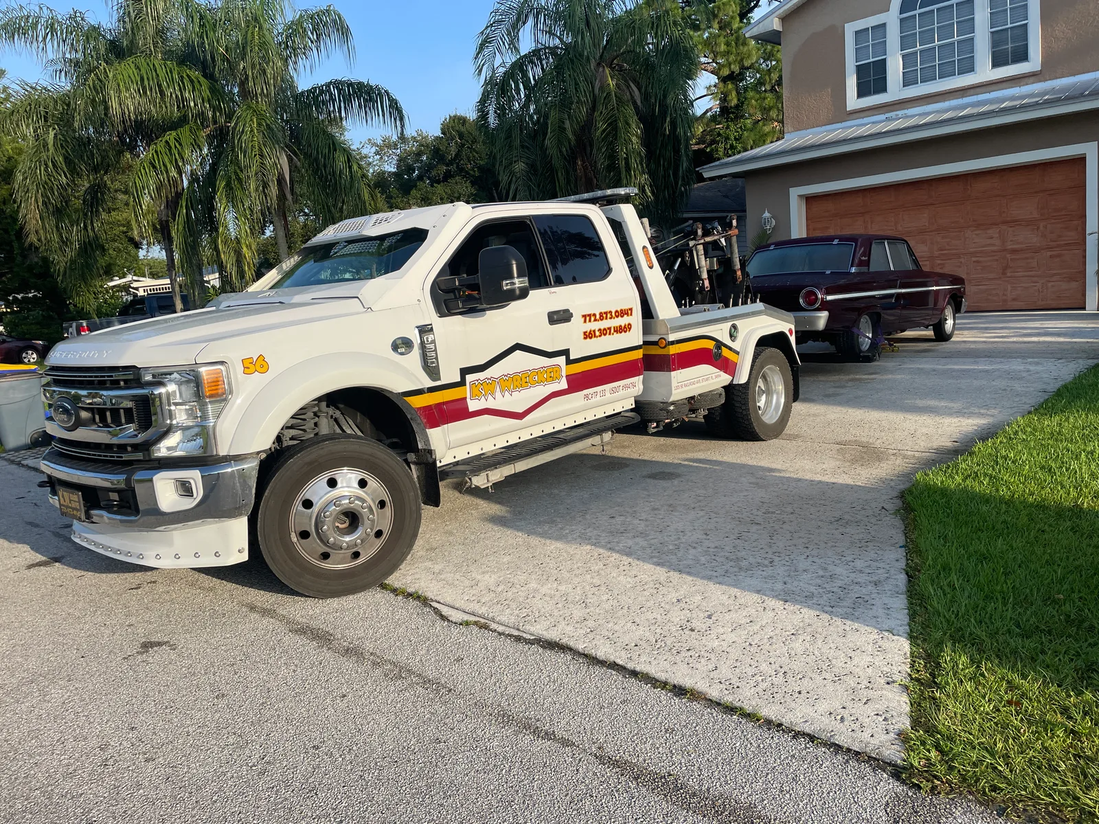 KW Wrecker Service light-duty wrecker towing a classic car from a residential driveway