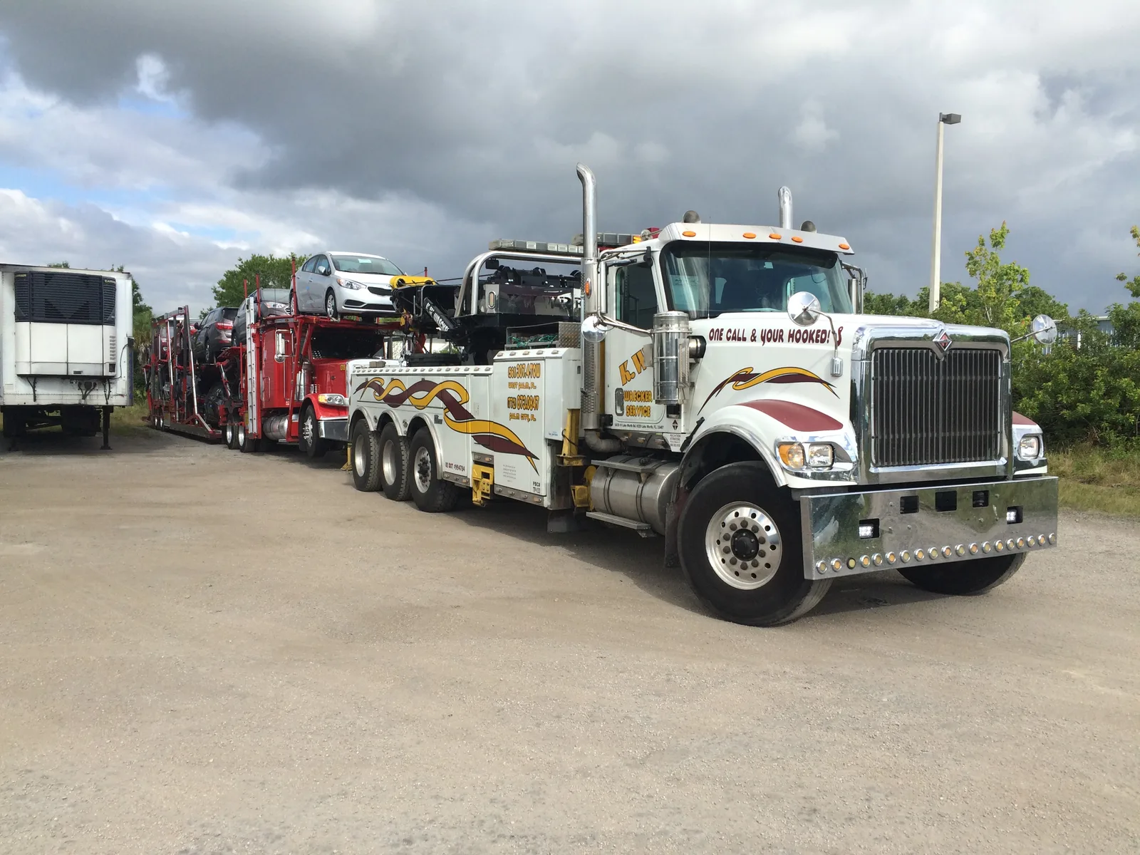 KW Wrecker Service heavy-duty rotator towing a loaded auto-transport truck