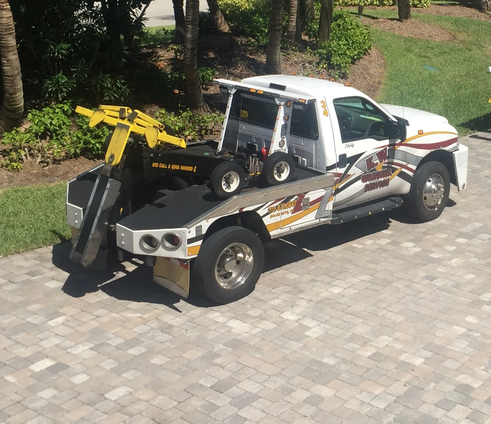 KW Wrecker Service light-duty wrecker parked on a residential paver driveway